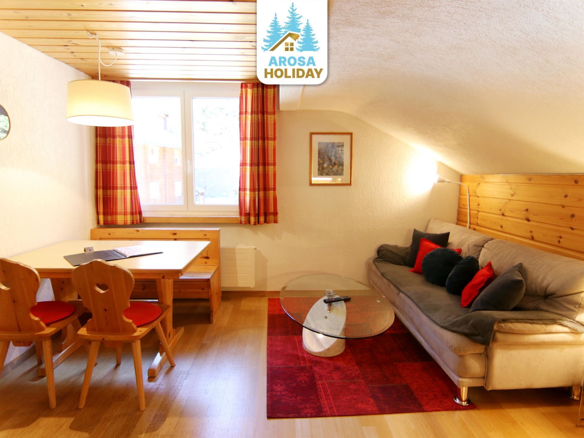 Una habitación acogedora con una mesa de madera para comer, sillas, un sofá y una mesa de centro de vidrio.