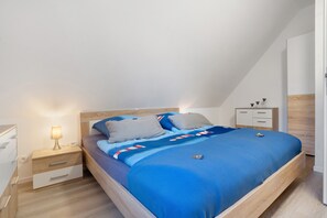 Ein Schlafzimmer mit Bett, Nachttischen, einer Lampe und einem Beistelltisch.