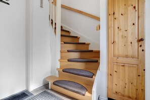 A wooden staircase with cushioned steps and a wooden door. - Apartment 'Villa Wiese  1' with Lake View, Shared Terrace and Wi-Fi (Katzow)
