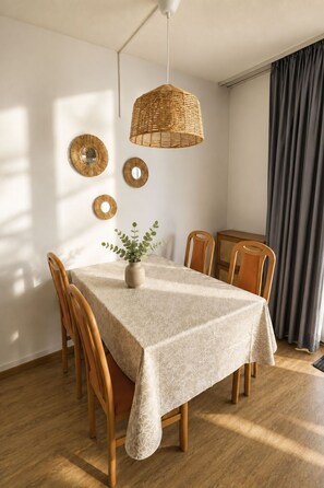 A dining area with a table set for four, surrounded by wooden chairs, a woven pendant light, and wall-mounted mirrors. - Majesta Leukerbad # 3-bed apartment, Bad, WC by Interhome (Leukerbad)