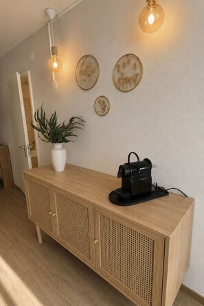A reception desk with a potted plant, a vintage radio, and wall-mounted light fixtures. - Majesta Leukerbad # 3-bed apartment, Bad, WC by Interhome (Leukerbad)
