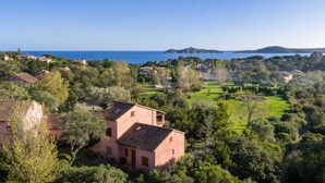 A coastal villa with a terracotta roof, surrounded by lush greenery and a clear view of the sea. - Duplex 400 meters from the ocean with a pool in a gated community (Zonza)