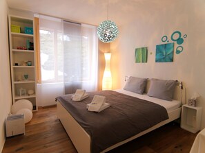 A modern bedroom with a large bed, bedside tables, a wardrobe, and a window with blinds. - Salis 02 by Arosa Holiday Appartement/Fewo, Dusche und Bad, WC, 4-Bettwohnung by Interhome (Arosa)