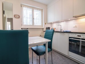 A compact kitchen with a window, a sink, and a built-in oven. - Casa Viktoria A37 by Arosa Holiday Appartement/Fewo, Dusche, WC, 4-Bettwohnung by Interhome (Arosa)