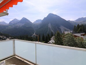 A balcony with a mountain view, a construction crane, and a building with a sloped roof. - Casa Viktoria A37 by Arosa Holiday Appartement/Fewo, Dusche, WC, 4-Bettwohnung by Interhome (Arosa)