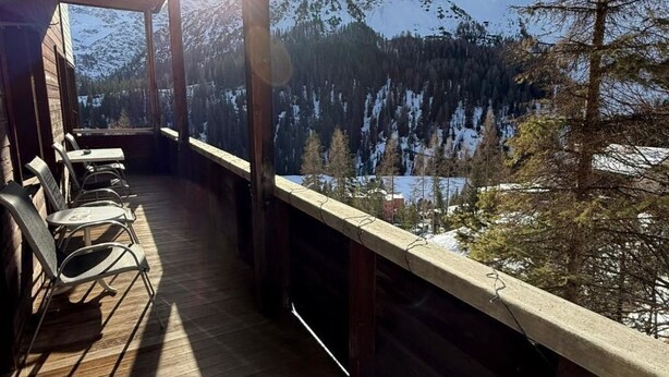 A wooden deck with chairs and a table, overlooking a snowy mountain landscape. - Miraflor Anita by Arosa Holiday Appartement/Fewo, Bad, WC, 6-Bettwohnung by Interhome (Arosa)