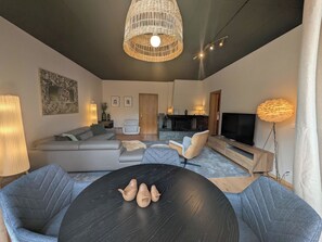 A modern living room with a sectional sofa, a round coffee table, and a television. - Miraflor Betty by Arosa Holiday Appartement/Fewo, Dusche und Bad, WC, 8-Bettwohn by Interhome (Arosa)