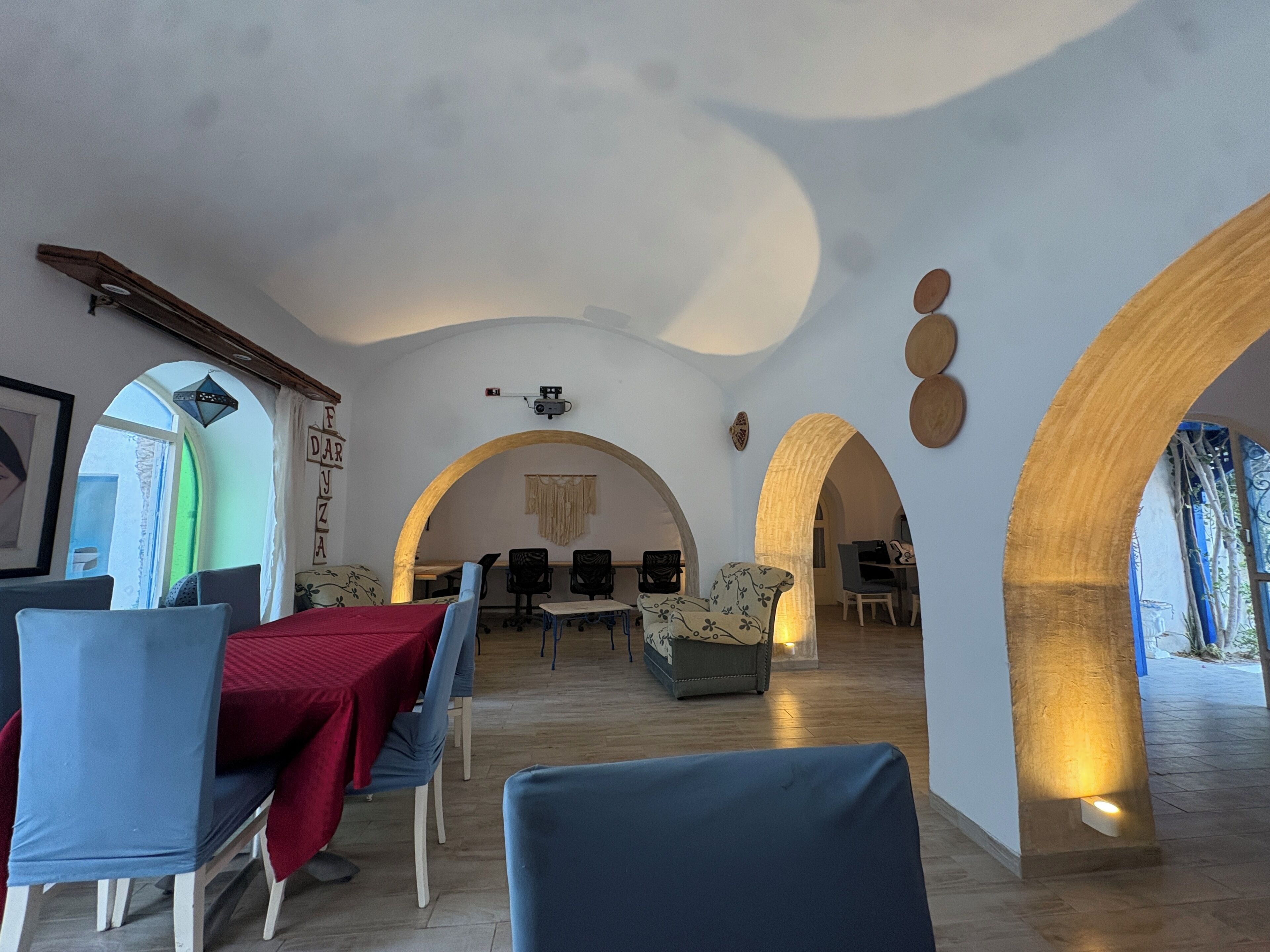 Un interior con comedor, asientos y una pantalla de proyector.