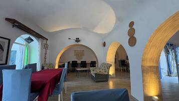 Un interior con comedor, asientos y una pantalla de proyector.
