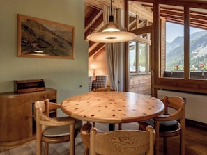 A wooden dining table with six chairs, a pendant light, and a painting on the wall. - Tschuggenweg 14 Appartement/Fewo, Bad, WC, 5-Bettwohnung 5-Bettwohnung by Interhome (Arosa)