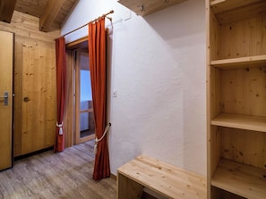 A wooden room with a door, a window with curtains, and a wooden bench. - Tschuggenweg 14 Appartement/Fewo, Bad, WC, 5-Bettwohnung 5-Bettwohnung by Interhome (Arosa)