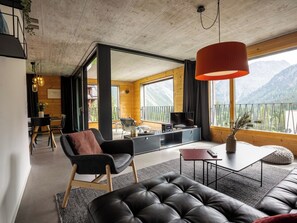 A modern living room with a sofa, a dining area, and a kitchen. - Haus Burgermeister Wohnung Schiesshorn Appartement/Fewo, Dusche oder Bad, WC, 4- by Interhome (Arosa)