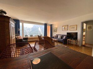 A living room with a view of mountains, a sofa, a television, and a dining table. - Casa Linda 7 by Arosa Holiday Appartement/Fewo, Dusche, WC, Balkon Linda 7 by Interhome (Arosa)