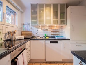 A modern kitchen with white cabinets, a stainless steel sink, and a built-in oven. - Casa Linda 7 by Arosa Holiday Appartement/Fewo, Dusche, WC, Balkon Linda 7 by Interhome (Arosa)