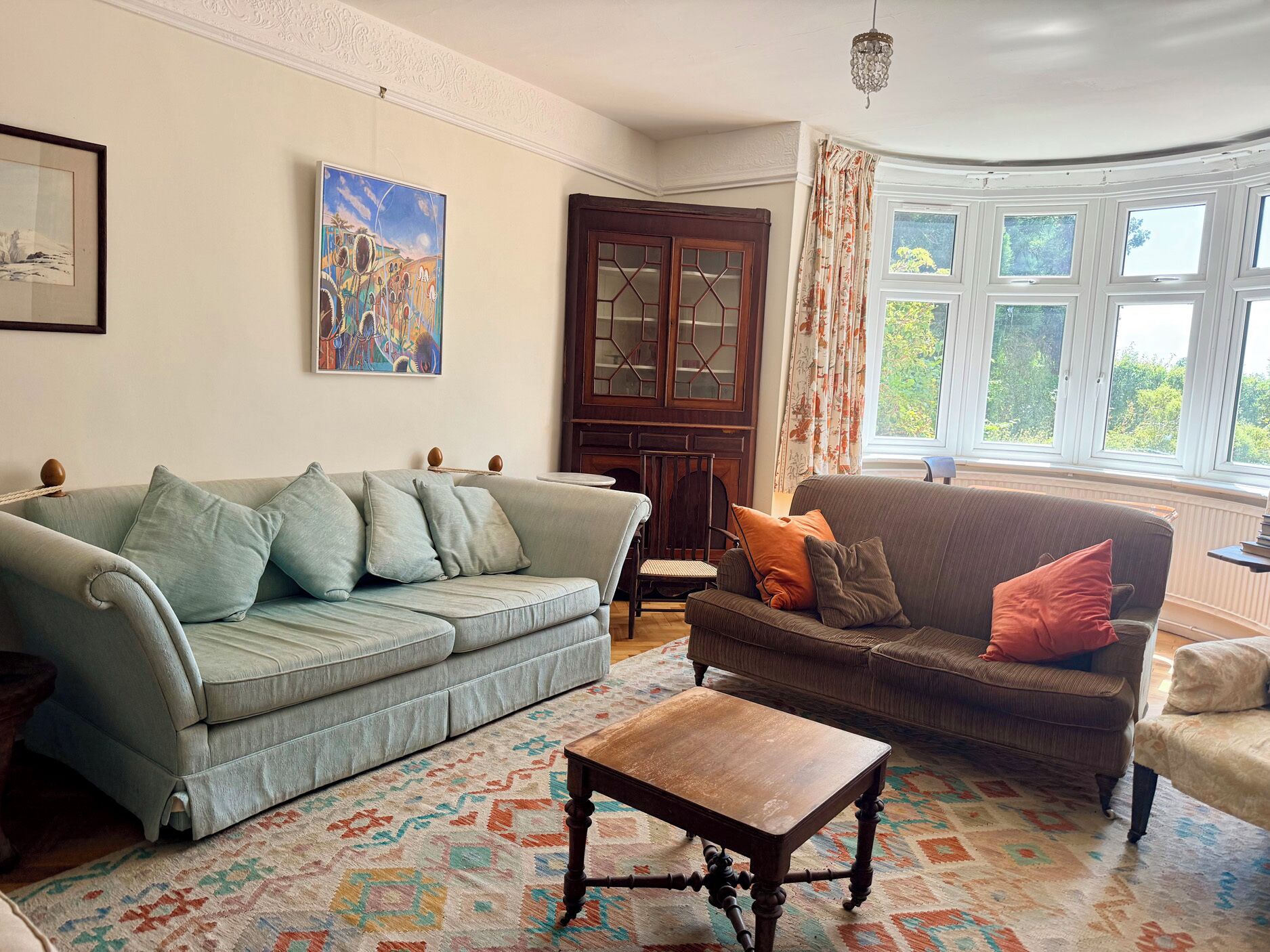 A living room with two sofas, a coffee table, and a patterned rug.