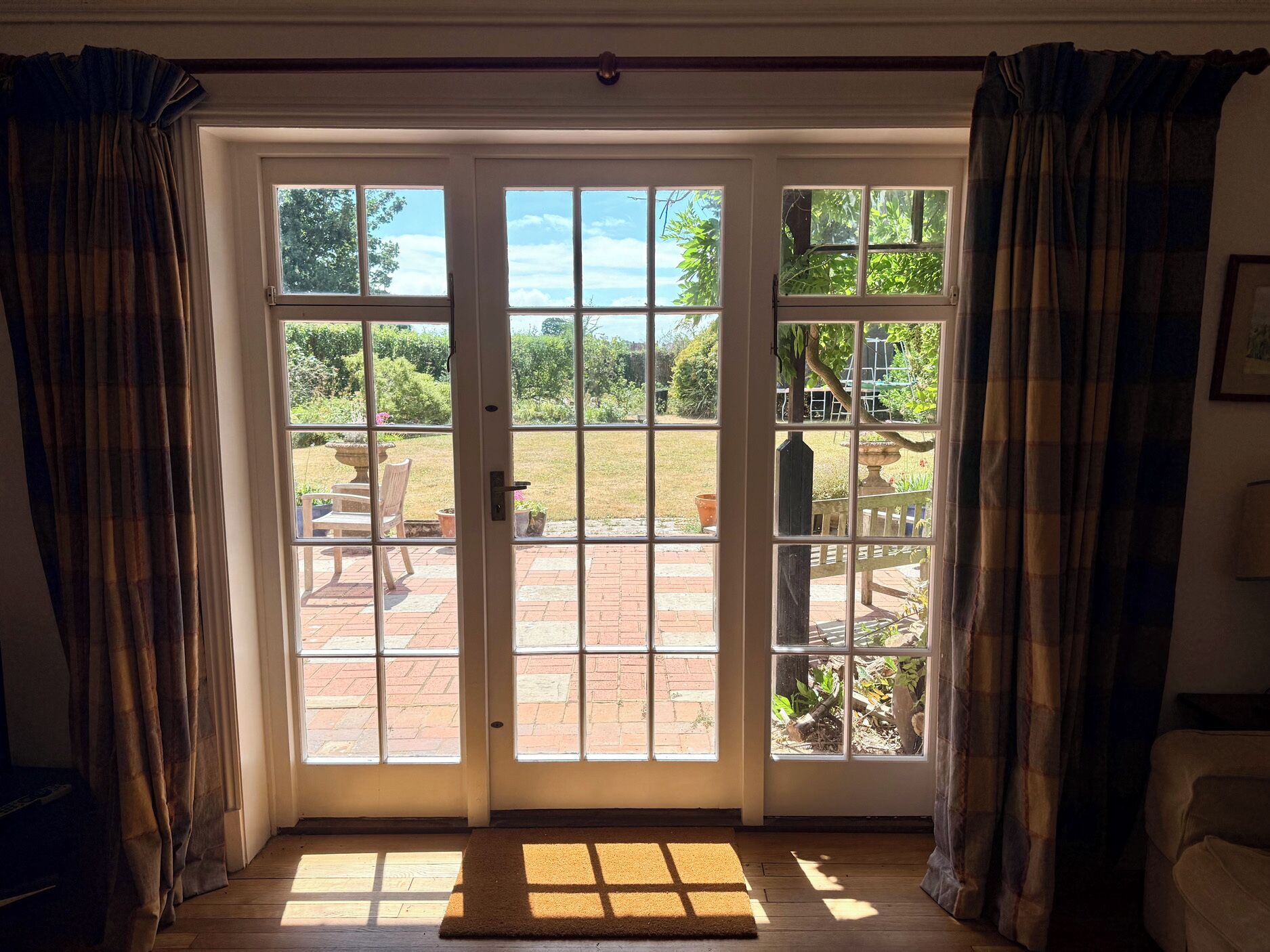 A room with a large sliding glass door leading to an outdoor patio area.