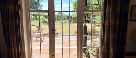 Una habitación con un amplio ventanal corredera que da a un patio al aire libre.