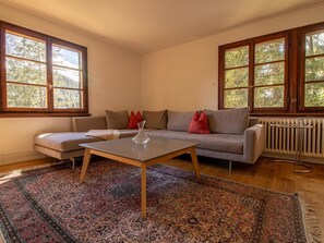 Ein Wohnzimmer mit einer Couch, einem Couchtisch und einem gemusterten Teppich.