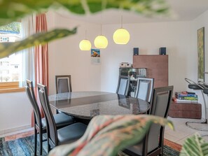 A modern dining area with a round table, chairs, pendant lights, and a view of the outdoors. - Casa Cresta C32 by Arosa Vacations Appartement/Fewo, Dusche und Bad, WC, 2 Schla by Interhome (Arosa)