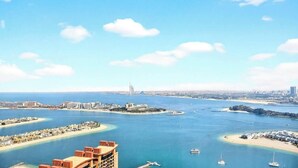 Paisagem costeira com uma ponte imponente, várias ilhas e uma marina com barcos.