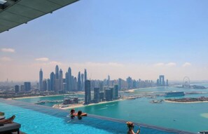 Vista a la piscina con vistas a un horizonte urbano, con edificios altos y un puerto deportivo.