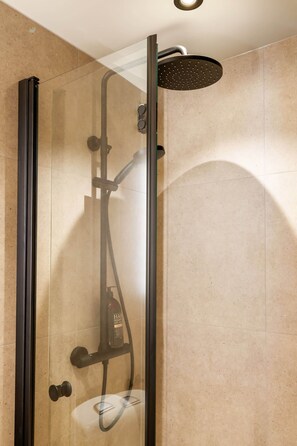 A glass-enclosed shower with a handheld showerhead and a wall-mounted faucet. - Explore Bergen | 24/7 Self check-in | 500m Torget (Bergen)