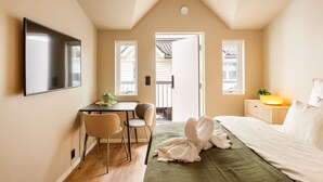 Ein Schlafzimmer mit Bett, Schreibtisch, Stühlen und einem Fernseher.