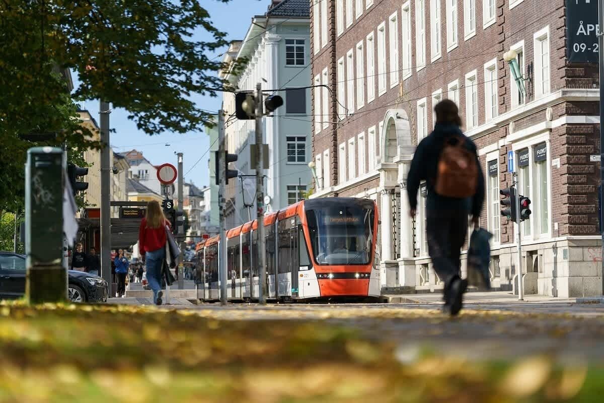 Um elétrico numa rua da cidade, com edifícios e pedestres.