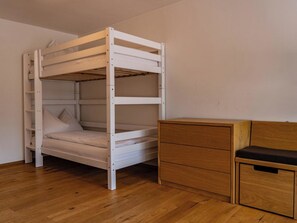 A bunk bed with a wooden frame and a wooden dresser with drawers. - Eden Mountain Resort - Wohnung "Bellavista" Appartement/Fewo, Dusche und Bad, WC by Interhome (Arosa)