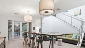 A modern interior with a dining area, a staircase, and a sofa. - Modern 2BR w/ Pool | Pet-Friendly | Unit #17 (Tampa)