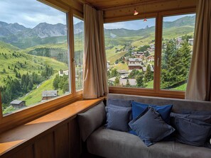 A room with a large window offering a view of a mountainous landscape and a village. - Chalet zum Stöckli by Arosa Holiday Appartement/Fewo, Dusche oder Bad, WC, 6-Bet by Interhome (Arosa)