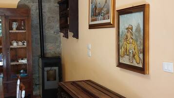 Une pièce avec un banc en bois, un mur en pierre et deux tableaux encadrés accrochés au mur.