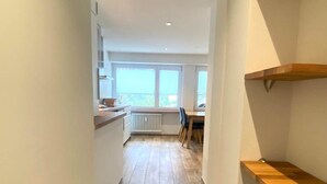 A narrow hallway with wooden flooring, white walls, and built-in wooden shelves. - Jäggi 44 by Arosa Holiday Appartement/Fewo, Dusche und Bad, WC, 3-Bettwohnung by Interhome (Arosa)