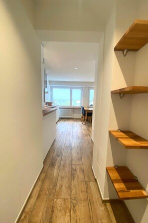 A narrow hallway with wooden flooring, white walls, and built-in wooden shelves. - Jäggi 44 by Arosa Holiday Appartement/Fewo, Dusche und Bad, WC, 3-Bettwohnung by Interhome (Arosa)