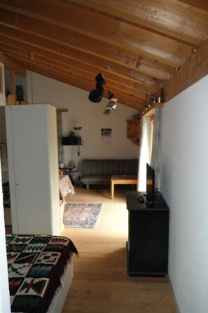 A room with a bed, a television, a sofa, and a small table. - Casa Cresta B72 Appartement/Fewo,  , 2-Bettwohnung 2-Bettwohnung by Interhome (Arosa)
