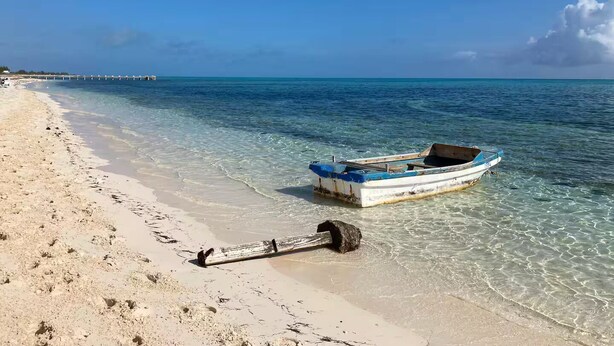 Een strand met een boot en anker aan de kust.