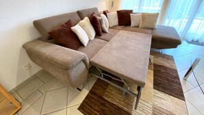 Ein modernes Wohnzimmer mit einer Couch, einem Couchtisch und einem Teppich.