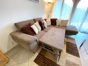 Ein modernes Wohnzimmer mit einer Couch, einem Couchtisch und einem Teppich.