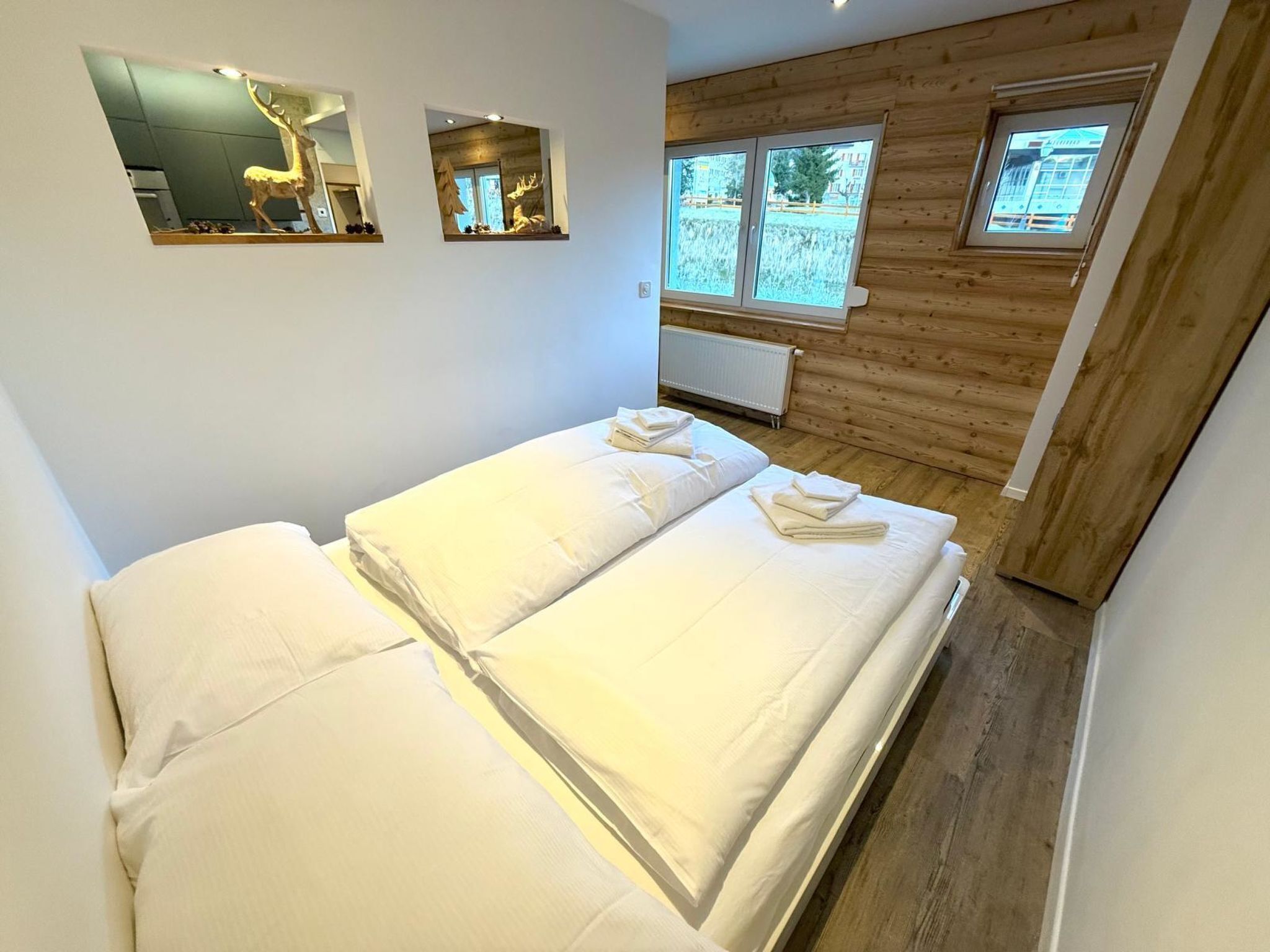 Una habitación con cama, paredes de madera y ventana con vista al exterior.