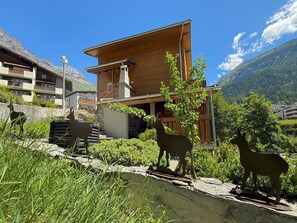 A wooden chalet with a balcony, surrounded by greenery and mountains. - Chalet Lucia 1 (EG) # 3-bed apartment, Dusche, WC 3-bed apartment, Dusche, WC by Interhome (Leukerbad)