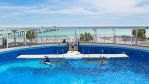 Ein Pool mit Blick auf den Ozean, eine überdachte Terrasse und ein Rettungsschwimmerstand.