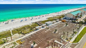 Luftaufnahme eines Hotels direkt am Strand mit Parkplatz, Strand und Meer.