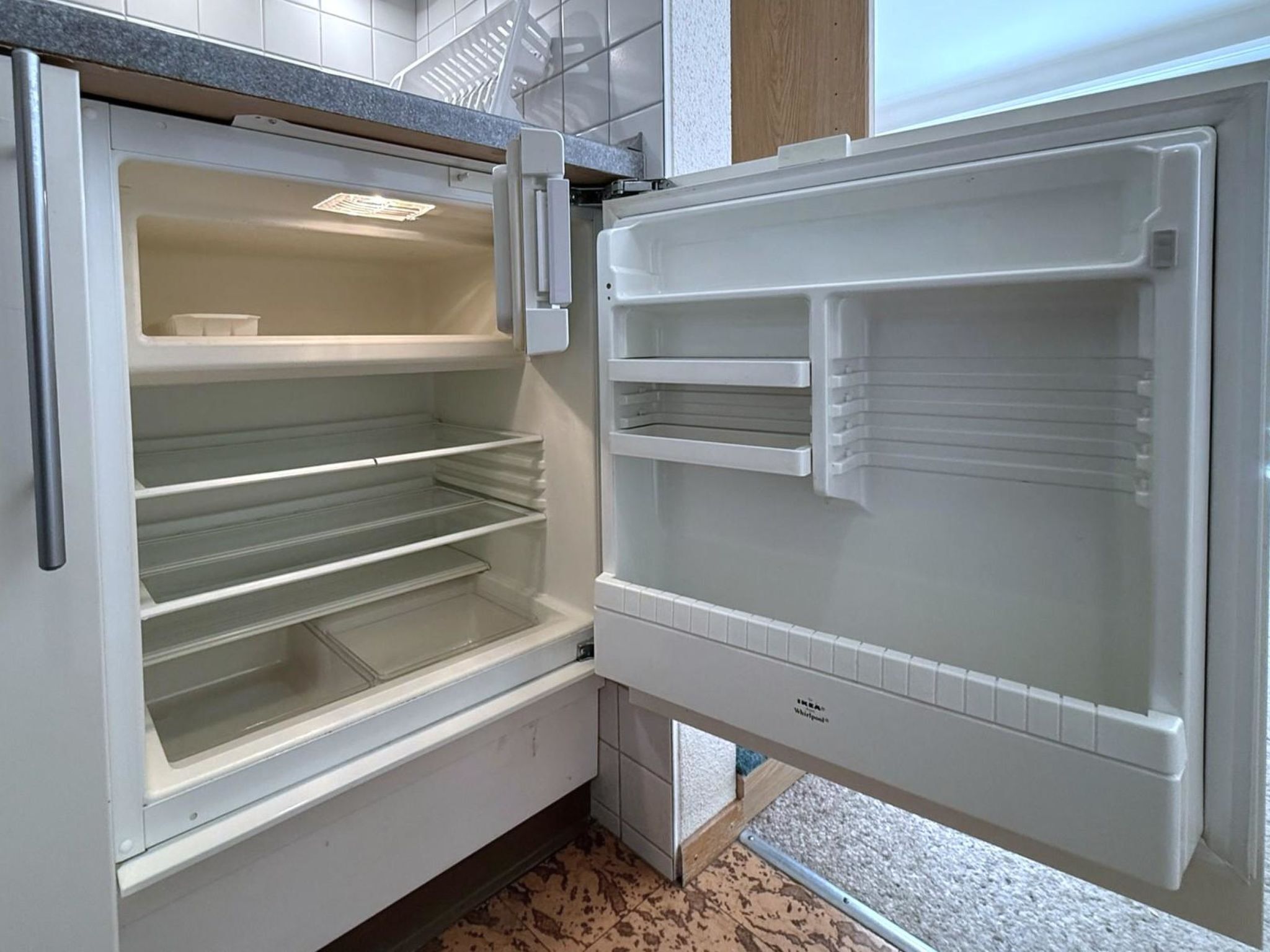 Ein offener Kühlschrank mit mehreren Einlegeböden und einem Gefrierfach.