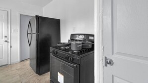 Una cocina con un refrigerador negro, una estufa y un microondas.