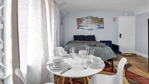 Ein Schlafzimmer mit einem Bett, einem Esstisch für vier Personen und einem Bild an der Wand.