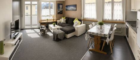 A modern apartment with a living area, dining space, and kitchen.