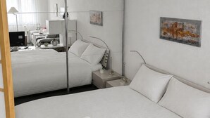 Una camera d'albergo con un letto grande, un comodino, una scrivania con una sedia, una lampada e un quadro appeso al muro.