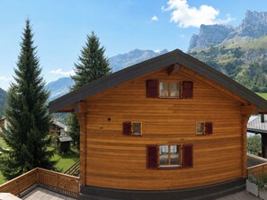 A wooden chalet with a balcony, multiple windows with shutters, and a view of mountains. - Residenz Darianne Leukerbad # 2-bed apartment, Bad, WC by Interhome (Leukerbad)