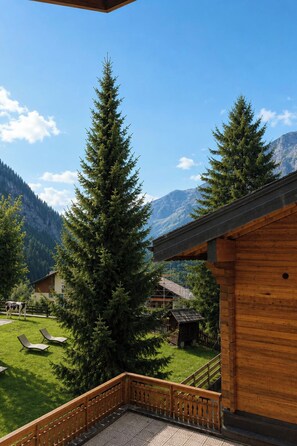 Ein Holzbau mit Balkon und Blick auf eine Berglandschaft.