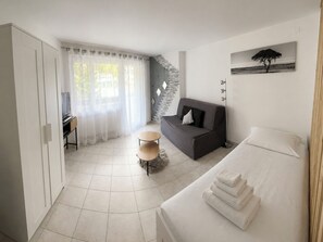 Ein modernes Schlafzimmer mit Bett, Sofa, Schreibtisch und Stuhl.